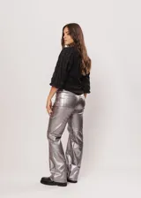 Pantalón de tiro alto color gris metalizado, confeccionado en gabardina stretch metalizada, con bolsillos laterales y cierre frontal con cremallera y botón.