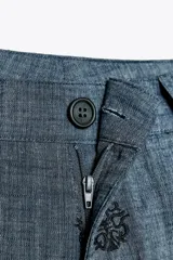Pantalón culotte de tiro alto con trabillas, bolsillos laterales y traseros. Detalle de bordados combinados a contraste. Cierre frontal con cremallera y botón.