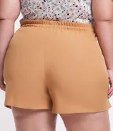 Short pollera color ocre con corte sastrero, botones delanteros forrados y pequeña abertura en la pierna.