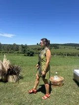 Vestido corto color verde lima con estampado floral blanco, corte cheongsam, cuello mao, sin mangas, con ribete negro y lazos decorativos en el lateral.