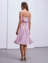 Vestido midi de gasa color lila con estampado de lunares blancos, escote en V, breteles finos regulables, espalda elastizada, delantera plisada con botones forrados y forro interno a tono.