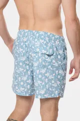 Short de baño celeste con estampado de flores blancas, cintura elástica con cordón ajustable, bolsillos laterales y suspensor de malla fina.
