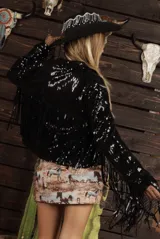 Campera negra de lentejuelas con flecos largos en mangas y ruedo.