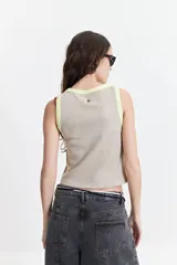 Musculosa acanalada color beige con borde contrastante amarillo flúor, de corte ajustado.