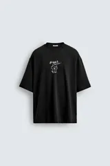 Camiseta negra de corte relaxed fit, cuello redondo y manga corta. Estampado frontal con dibujo de gato y texto en japonés.