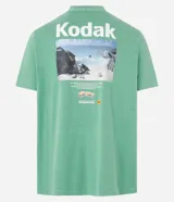 Remera verde con estampa de la marca Kodak y photoprint de playa paradisíaca.