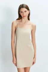 Vestido corto color beige con tirantes finos.