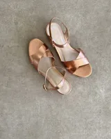 Sandalias bajas negras con tiras finas cruzadas y tobillera con hebilla.