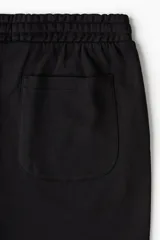 Short negro de felpa liviana de mezcla de algodón, con cintura elástica y cordón para ajustar, bolsillos al bies y un bolsillo abierto atrás.