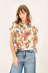 Camisa de corte amplio con cuello camisero y botones a tono.
