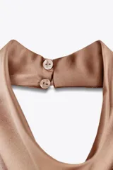 Top color champagne de cuello halter con espalda descubierta y cierre trasero con botones ocultos.
