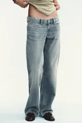 Pantalón de jean celeste claro, de tiro bajo, corte wide leg y largo hasta el tobillo. Tiene cinco bolsillos, cierre frontal con cremallera y botón metálico.