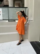 Vestido camisero color verde lima, de lino, fabricado en Italia, de manga corta, con botones de nácar y un volado en el ruedo final. Además, cuenta con un volado superior en un solo lado, creando un efecto irregular y con diseño.