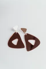 Par de aros colgantes con forma triangular calada color cobre y pieza superior triangular blanca.