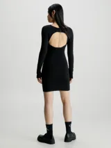 Vestido corto negro de punto de algodón orgánico, con cuello redondo, mangas largas y espalda descubierta con cierre de gancho.