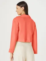 Blazer cropped color naranja con solapas y cierre frontal con botones.