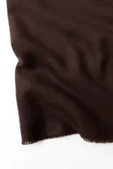 Bufanda rectangular color marrón chocolate, confeccionada en mezcla de viscosa con acabado desflecado.