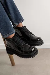 Borcegos negros de cuero charol, con punta cuadrada, cordones y suela track.