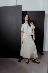 Pollera midi de tul color crudo con brillos plateados y cintura elástica.