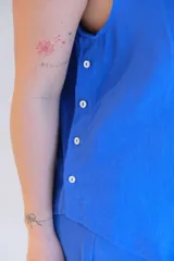 Musculosa azul con cuello redondo y botones decorativos en el lateral.
