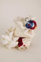 Aros colgantes con argolla de acero quirúrgico y dos dijes circulares de cristal de Murano, uno azul y otro rojo.