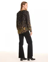 Blusa de gasa estampada en negro y amarillo, marca Zac & Rachel. Cuello a la base, escote en V con abertura de botones y manga larga con presilla y botón para regular el largo.