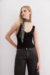 Musculosa tejida de punto compacto, color negro, con escote pronunciado en V y calce al cuerpo.