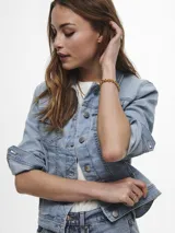 Chaqueta de jean celeste de corte clásico, con mangas largas con puños abotonados, cierre frontal con botones metálicos y bolsillos delanteros con solapa y botón.