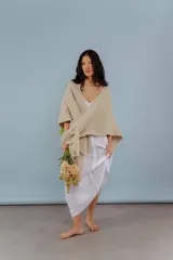Ruana de lana merino color beige, tejida a mano con detalles de brillos y flecos.