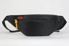 Riñonera de nylon negro con cierre doble y correa regulable, diseñada para llevar lo esencial.