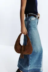Bolso de hombro marrón de serraje con asa corta y flecos decorativos.