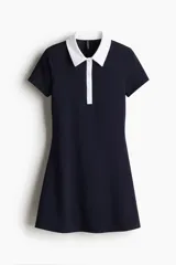 Vestido corto azul marino con cuello blanco, tapeta de botones y pollera acampanada.