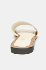 Sandalia plana color crema, de cuero, con detalle a contraste en la plantilla y punta redonda.