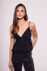 Blusa negra de algodón con breteles finos, escote en V con detalles de encaje y volados en el ruedo.