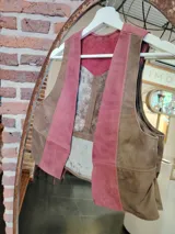 Chaleco de cuero marrón y rosa con diseño de bloques de color.