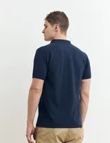 Chomba verde de piqué de algodón con cuello clásico y tapeta de dos botones. Logo bordado en el pecho.