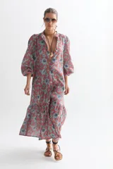 Vestido midi de lino color ladrillo con estampado floral celeste, corte recto, cuello mao, mangas abullonadas 3/4 con puños elásticos, cierre frontal con botones y falda con volantes.