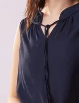 Blusa azul de gasa marca Zac & Rachel, con cuello a la base, escote en V y lazo de ajuste.