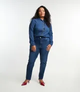 Camisa de jean azul oscuro, de corte clásico, con cuello tradicional, mangas largas con puños abotonados, bolsillo en el pecho y cierre frontal abotonado.