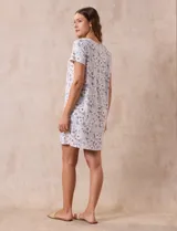 Camisón corto negro con lunares blancos, de tejido suave y escote redondo con detalle plisado y moño blanco.
