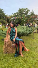 Vestido largo de fiesta color verde esmeralda con detalles en rojo. El top es de escote halter con jaretas y la falda es larga con aberturas laterales.