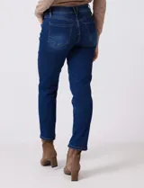 Jean skinny de mujer, color azul oscuro con efecto lavado, tiro medio, con pretina, botón, cierre y bolsillos delanteros y traseros.