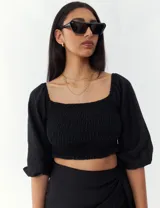 Top negro con escote cuadrado, mangas 3/4 abullonadas y cuerpo fruncido.