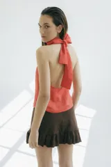 Top sin mangas color naranja, con cuello halter y espalda descubierta. Confeccionado en lino.