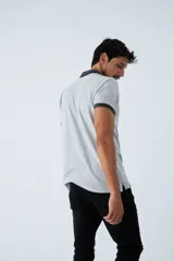 Remera tipo polo color ocre, de corte clásico, con cuello y mangas con terminaciones a contratono en azul marino y blanco.