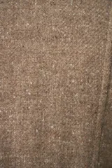 Chaqueta corta entallada color beige, con escote en V, manga larga, cierre frontal con lazo fijo y bolsillos escondidos. Confeccionada en lana fina sin teñir, diseñada exclusivamente por Don Baez.