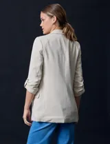 Blazer rojo de crepe marca Tahari, con cuello con solapa y abertura central. Tiene mangas 3/4 regulables con presilla y botón, bolsillos delanteros y forro interno.