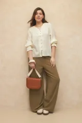 Cartera de símil cuero negra con correa de tela desmontable y regulable, incluye un compartimiento interno y dos bolsillos adicionales.