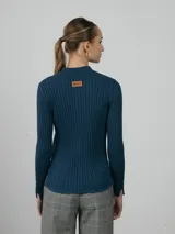 Camisa azul de tejido de punto acanalado, con cuello polo, mangas largas y cierre frontal con botones.