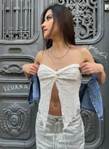 Top strapless de tela drapeada color blanco con elasticidad en la espalda.